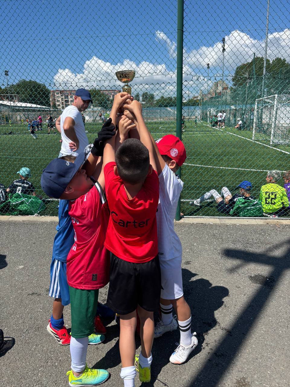 Юні футболісти FC FRAME разом піднімають кубок після змагання